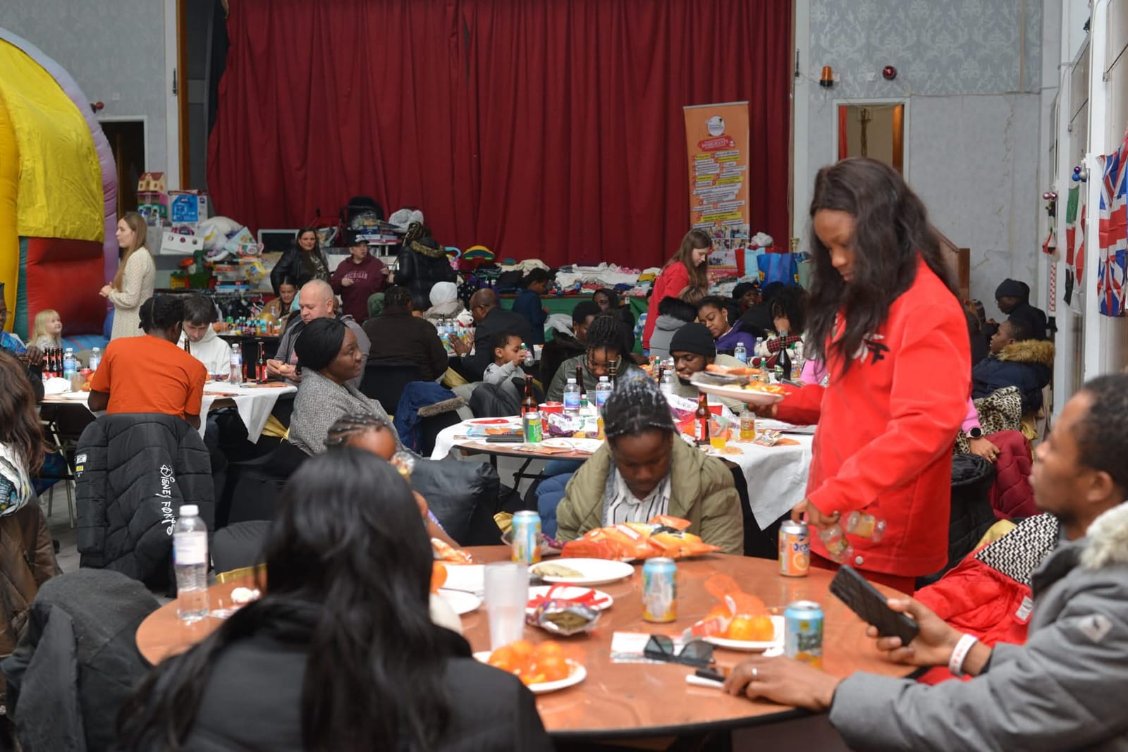 Woman in red jacket serving food at community event