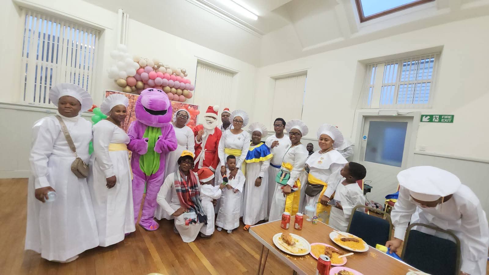 Large group of volunteers in chef outfits with children
